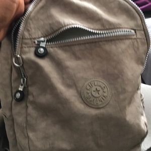 A tan Kipling’s small backpack
